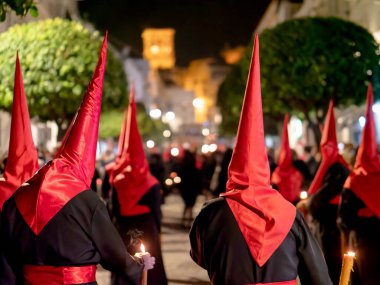 Bir grup tövbekar geleneksel siyah ve kırmızı cüppeli dini bir hafta boyunca İspanya 'da dar bir şehir sokağında yürüyorlar..