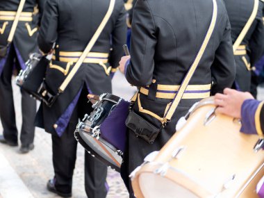 İspanya 'da geleneksel bir Kutsal Hafta geçit töreninde yürürken siyah ve altın üniformalı müzisyenlerin arkasından yaklaş..