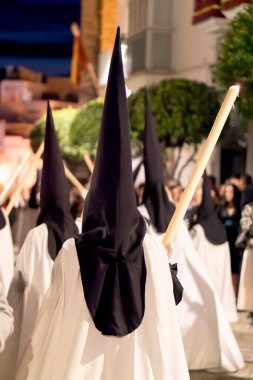 İspanya 'da kutsal bir hafta boyunca geleneksel siyah başlıklar takıp mumlar taşıyan tövbekârlar görülüyor...