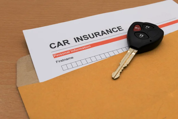 Araba sigortası başvuru formu ve anahtar kahverengi zarf üstünde — Stok fotoğraf