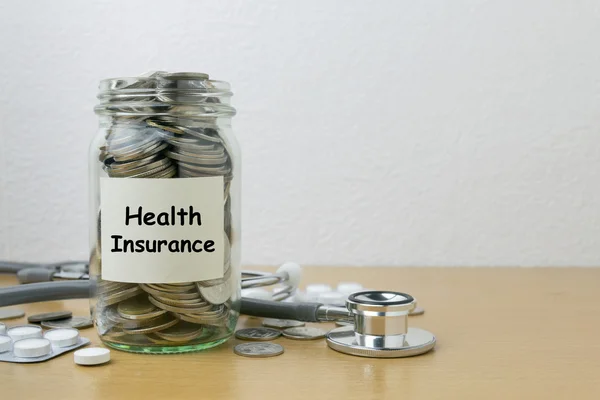 Cam şişe içinde sağlık sigortası için kaydetme para — Stok fotoğraf