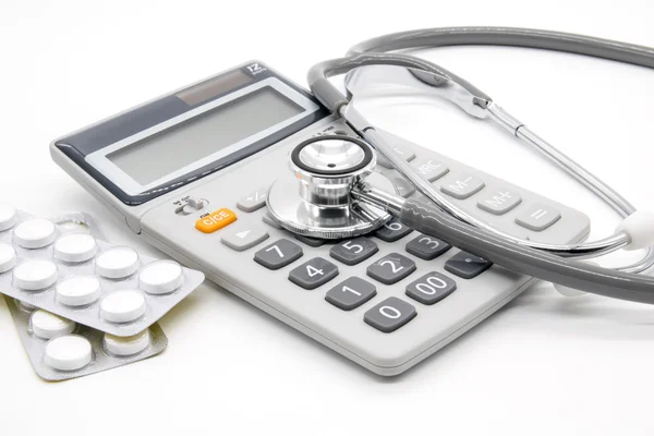 Calculator and stethoscopes on white background — Stock Photo, Image