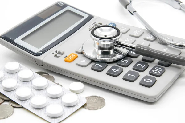 Calculator and stethoscopes on white background — Stock Photo, Image