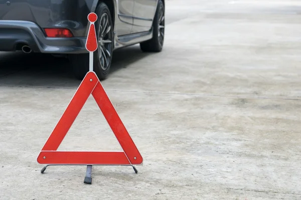 Sinal de carro partido numa estrada com um carro avariado — Fotografia de Stock