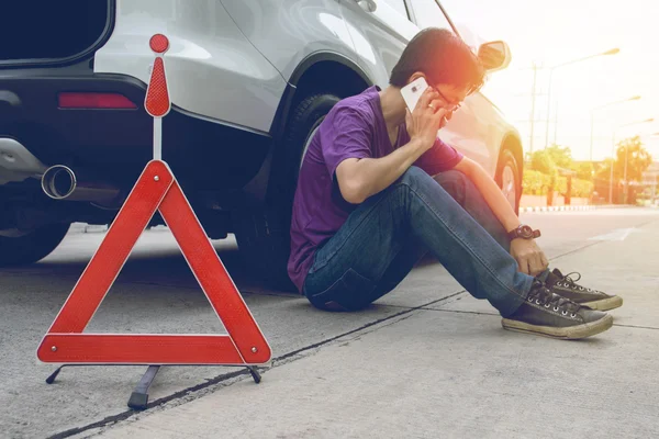 Homem telefonando para ajuda com um carro quebrado — Fotografia de Stock