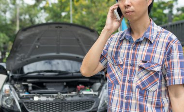 Arızalı bir araba için yardım isteyen bir adam.