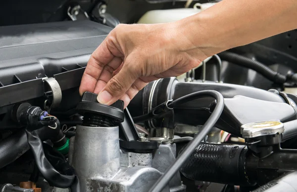 Um mecânico está abrindo a tampa de óleo de um motor de carro . — Fotografia de Stock
