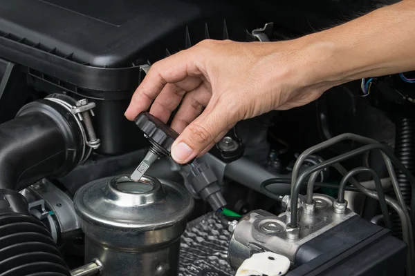 Um mecânico está abrindo a tampa de óleo de um motor de carro . — Fotografia de Stock