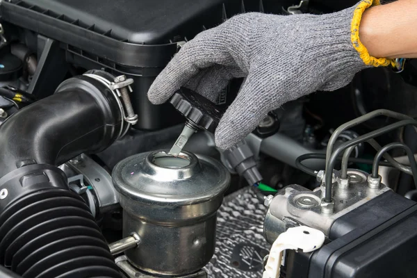 A mechanic is opening the oil cap from a car engine. — Stock Photo, Image