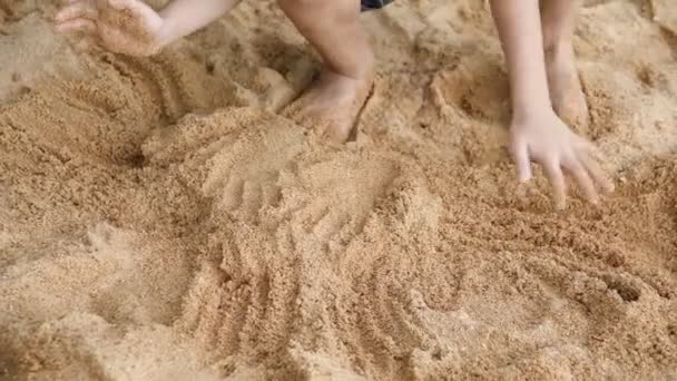 Jongen spelen met zand op strand — Stockvideo