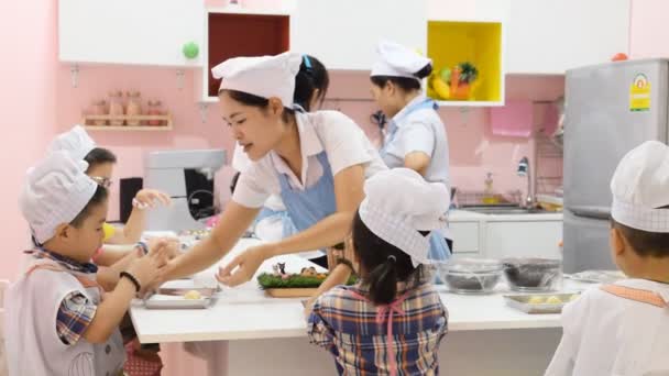 Tajlandia Bangkok-19 lipca: Kobieta z dzieckiem uczy ją gotować. Dziecko ucznia klasy gotowanie, października 19,2016 w Tajlandii — Wideo stockowe