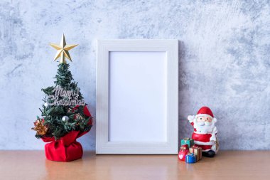 Resim çerçevesi ve Noel süsü Noel Baba, ağaç ve hediye ahşap masada. Noel ve Mutlu Yıllar konsepti