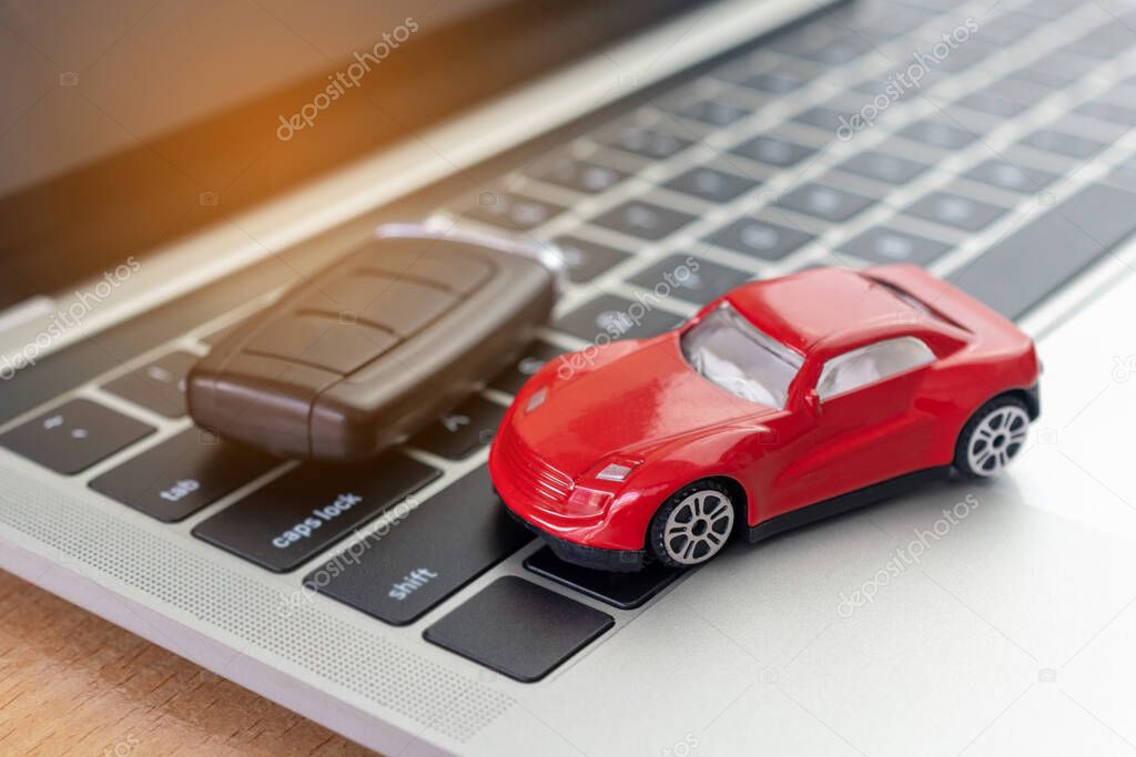 Car model, Key and Notebook on wooden desk. car business concept such as transportation, rental, sell and buy