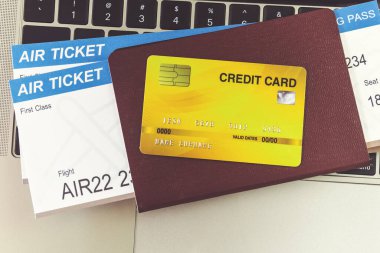 Masadaki dizüstü bilgisayarın yanında kredi kartı ve pasaportlar. Online bilet rezervasyonu kavramı