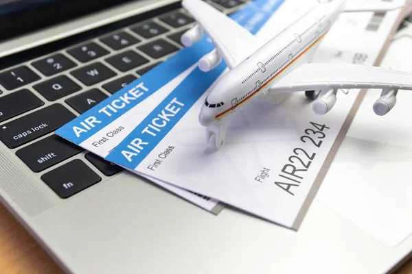 laptop computer and airplane and money on table. Online ticket booking concept