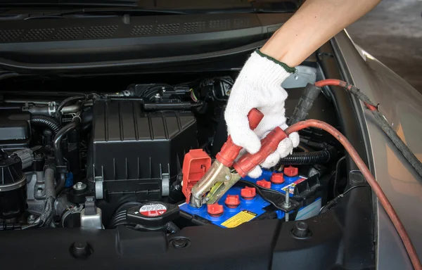 Automotive technician charging vehicle battery — Stock Photo, Image