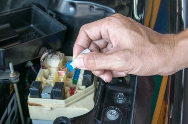 Auto mechanic checking a car fuse clipart
