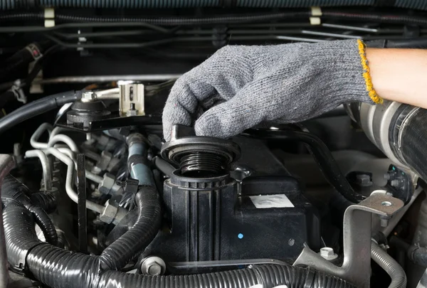 Um mecânico está abrindo a tampa de óleo de um motor de carro . — Fotografia de Stock