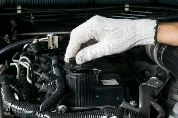 Um mecânico está abrindo a tampa de óleo de um motor de carro . — Fotografia de Stock