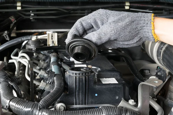 Mechanik jest otwarcie WPR oleju z silnika samochodu. — Zdjęcie stockowe