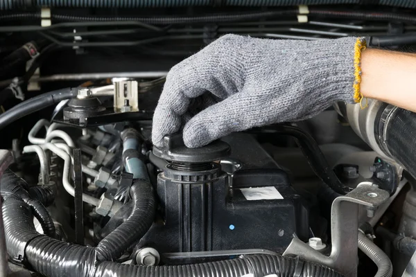 Um mecânico está abrindo a tampa de óleo de um motor de carro . — Fotografia de Stock