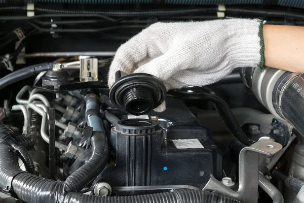 Un mécanicien ouvre le bouchon d'huile d'un moteur de voiture . — Photo