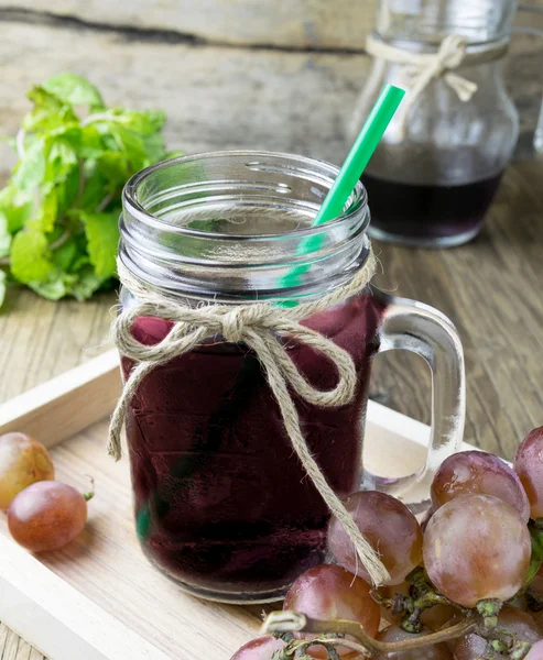 Свежий виноград и сок на деревянном столе — стоковое фото