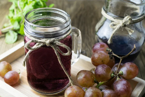 Свежий виноград и сок на деревянном столе — стоковое фото