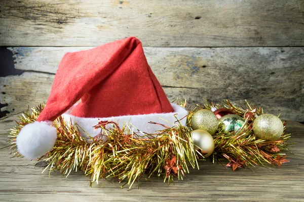 Cappello Santa con decorazioni natalizie su sfondo vecchio in legno . — Foto Stock