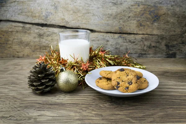 Biscoitos e um copo com leite na mesa de madeira — Fotografia de Stock