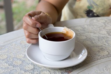 Tablo arka plan üzerinde elinde çay beyaz kupa