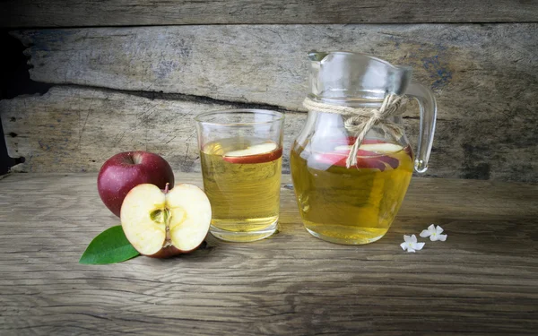 Appelsap en appels op een houten tafel — Stockfoto