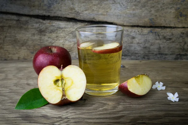 Sumo de maçã e maçãs em uma mesa de madeira — Fotografia de Stock