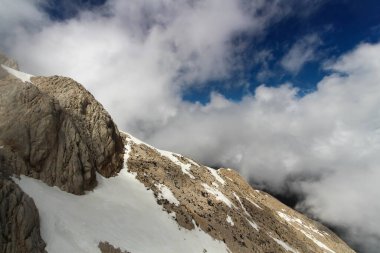 Türkiye 'nin Tahtal Dağı' nın karla kaplı zirvesinden nefes kesici bir kış sahnesi, Akdeniz kıyı şeridi ile dağların üzerinde sürüklenen bulutları gösteriyor..