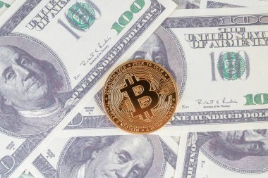 100 dolarlık banknotların üzerindeki altın bitcoin.