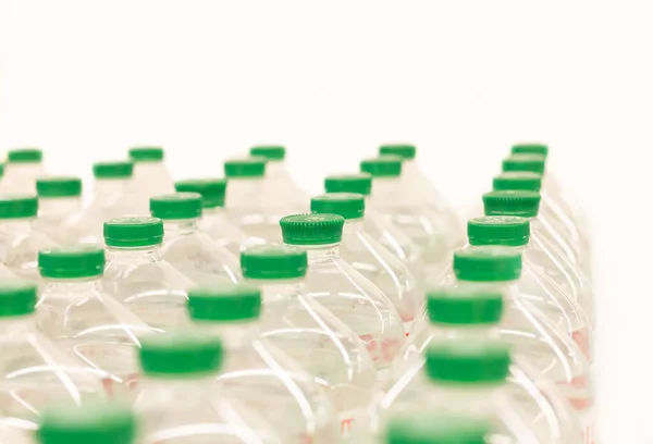 Water bottles with green plastic caps on white background