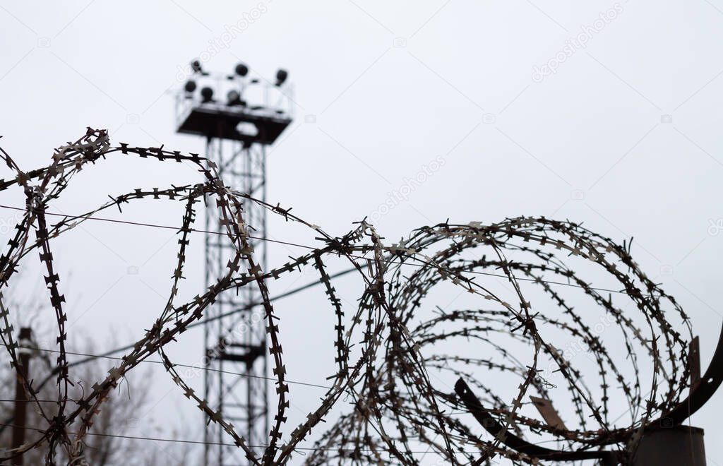 Barbed wire fence on patrol tower background