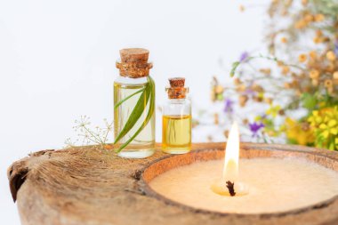 İki önemli bitkisel yağ şişesi ve yanan organik mum.