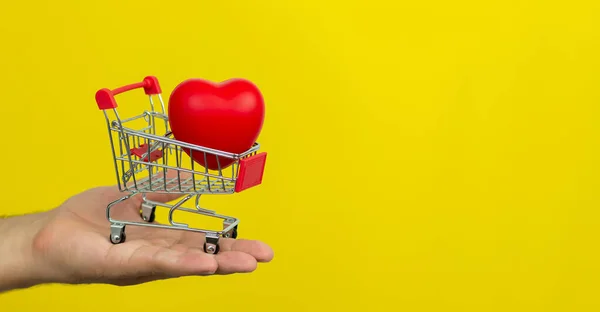 Man Holding Small Cart Red Heart Yellow Background Banner Copy — Stock Photo, Image