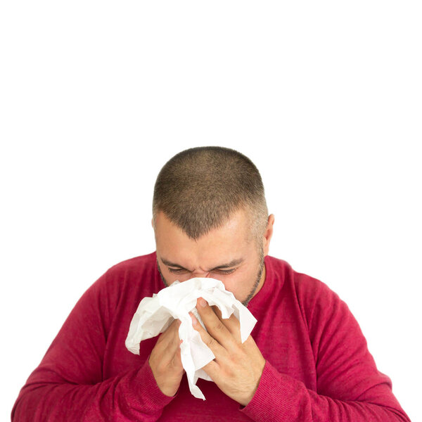 Young man holding paper handkerchief and sneezing isolated on white background with copy space