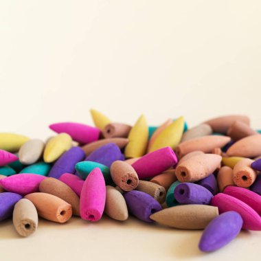 Doğal renkli tütsü konileri bej arka planda üst üste yığılır, boşluğu kopyala