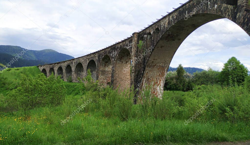 Old railway stone bridge or viaduct in spring mountains