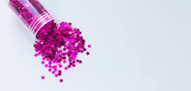 Cam şişeden dökülen mor konfeti, diy ya da bayram dekoru için malzeme.