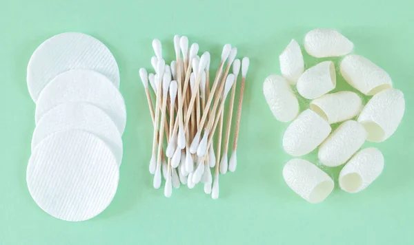 Organic cotton cosmetic removers and skin care products: pads, cotton swabs, silkworm cocoons top view