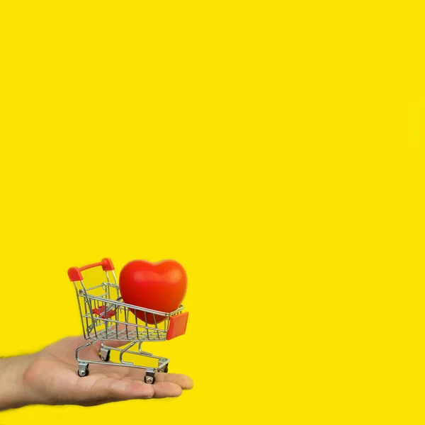 Man Holding Small Cart Red Heart Yellow Background — Stock Photo, Image