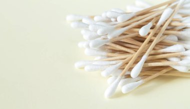 Bir yığın bambu pamuk çubuğu ya da tomurcuk bej arkaplanda üst görünüm, kopyalama alanı