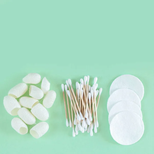 Organic cotton cosmetic removers and skin care products: pads, cotton swabs, silkworm cocoons top view