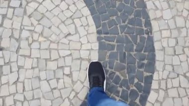 Gündüz vakti kaldırımda kot pantolon ve spor ayakkabı giyen bir kişi (normal / normal))