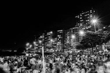 Yeni yılın (Reveillon) gece görüntüleri. Parti, konserler ve havai fişeklerle dolu bir etkinlik. İnsanlar Rio de Janeiro, Brezilya 'da bir plajda meydana gelen patlamaların ışık ve renklerini gözlemliyor.