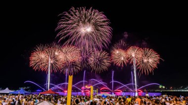 Yeni yılın (Reveillon) gece görüntüleri. Parti, konserler ve havai fişeklerle dolu bir etkinlik. İnsanlar Rio de Janeiro, Brezilya 'da bir plajda meydana gelen patlamaların ışık ve renklerini gözlemliyor.
